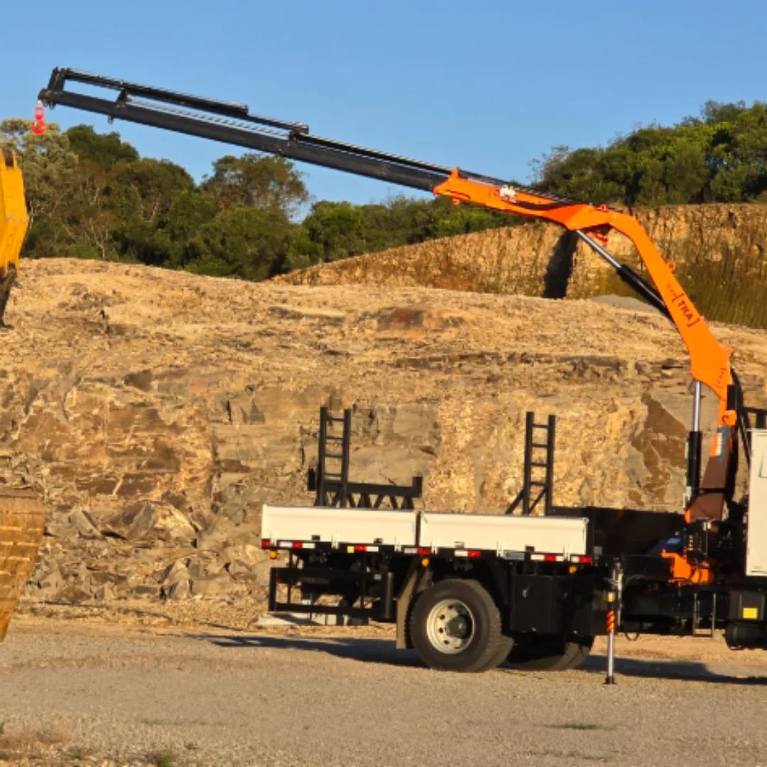 Guindaste articulado Munck TKA 11.900 instalado em caminhão levantando carga
