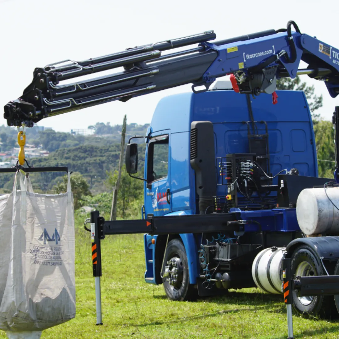 Guindaste articulado Munck TKA 48.700 instalado em caminhão içando carga