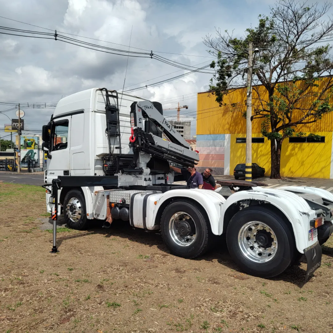 Guindaste articulado Munck TKA 9.900 instalado em caminhão, ideal para içamento e movimentação de cargas pesadas